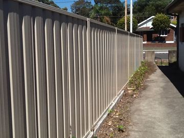 New light grey Colorbond privacy fence along the same concrete path