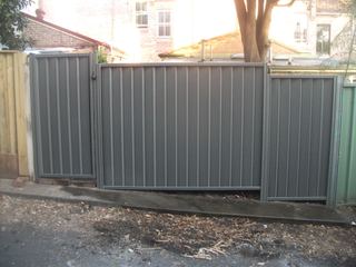 Finished charcoal Colorbond fence with a matching pedestrian gate on the street boundary