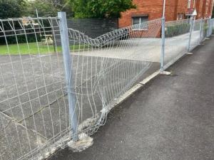Damaged mesh fence before replacement