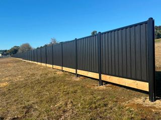 Long Black Ash woodgrain steel fence on a timber plinth