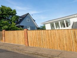 Vertical timber paling fence with brick piers
