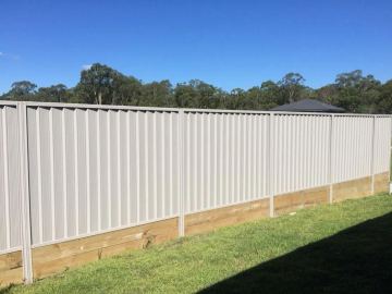 Installed light grey Colorbond sheets sitting on a timber sleeper wall.