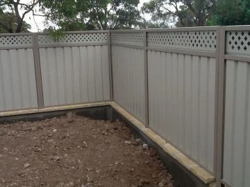 Installed Colorbond sheets sitting on a timber sleeper wall.