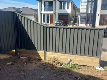 Charcoal Colorbond privacy fence turning a corner on a new residential block