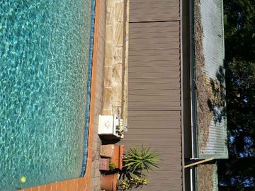 Overhead view of a brown Colorbond privacy fence beside a swimming pool and timber deck