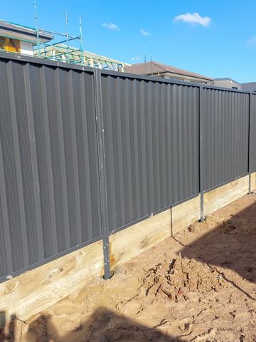 Long charcoal Colorbond privacy fence on a new dirt block