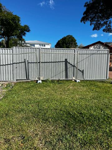 Galvanised mesh temporary fence panel standing on a residential lawn