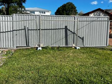 Galvanised mesh temporary fence panel standing on a residential lawn