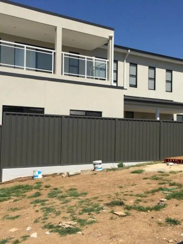 Installed Colorbond sheets sitting on a timber sleeper wall.