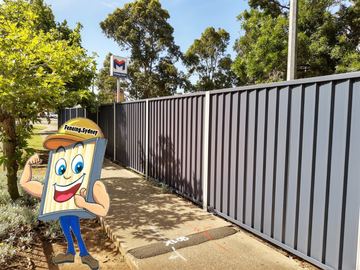 Charcoal Colorbond privacy fence along a concrete footpath