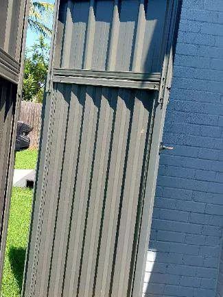 Installed Colorbond sheets forming a privacy boundary with a matching gate opening.