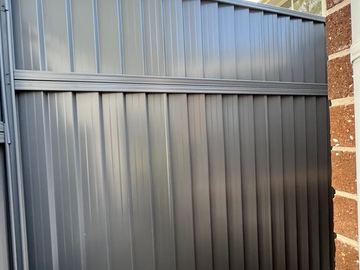 Close view of mid grey Colorbond sheets returning to a brick house wall
