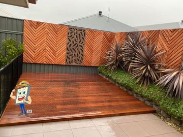 Timber herringbone screen with a decorative metal inlay panel beside a polished timber deck