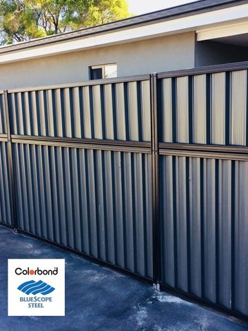Dark aluminium horizontal slat fence on a house boundary with a matching corrugated bay