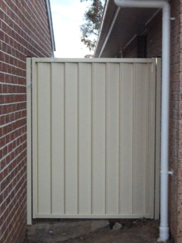 Installed Colorbond sheets forming a privacy boundary with a matching gate opening.