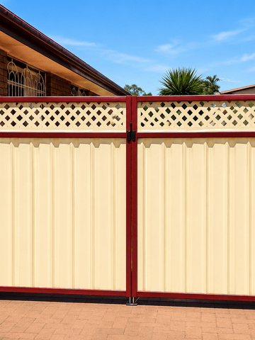 The scene shows a mid grey corrugated steel fence where a gate sits in the run, lattice tops the panels, sleepers form the base.