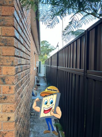 Dark Colorbond privacy fence filling a narrow side passage against a brick wall