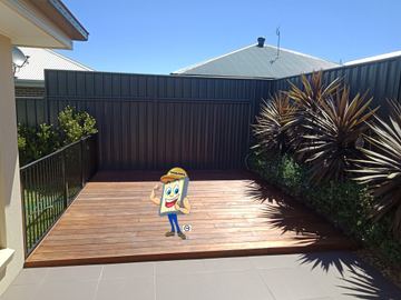 Charcoal Colorbond privacy fence with a slat height extension around a timber deck