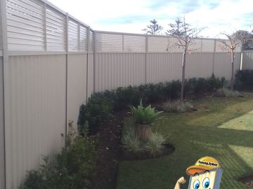 Cream Colorbond privacy fence with a full slat height extension in a garden
