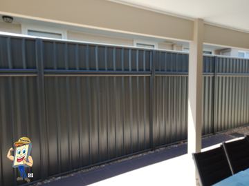 Charcoal Colorbond privacy fence running under a verandah