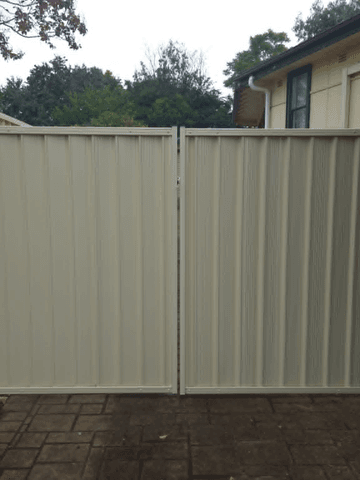 Cream Colorbond double driveway gate on a suburban drive