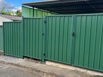 Green Colorbond double gate at a factory driveway