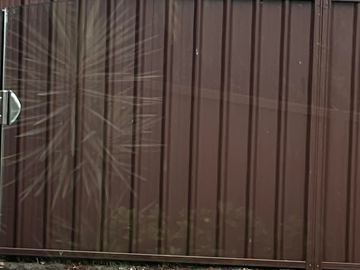 Close view of brown Colorbond sheets and a gate latch