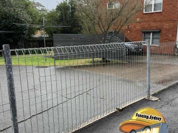Galvanised mesh fence and double gate across an apartment carpark
