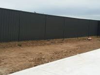 Black Colorbond fence along a concrete path