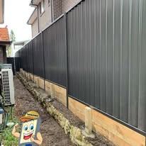 Black Colorbond fence on a timber plinth