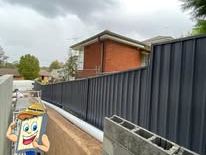 Black Colorbond fence stepping up a slope