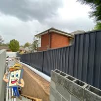 Black Colorbond fence stepping up a slope