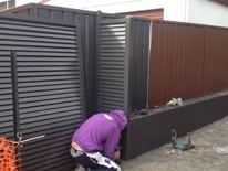 Black louvre double gate being fitted
