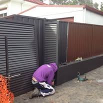 Black louvre double gate being fitted