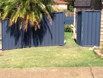 Blue Colorbond fence and gate in a backyard