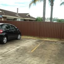 Brown Colorbond fence across a driveway