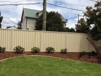 Cream Colorbond fence along a front lawn