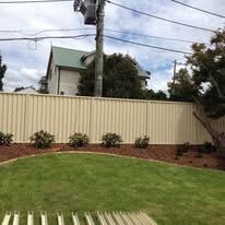 Cream Colorbond fence along a front lawn