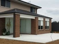 Dark grey Colorbond fence beside a brick porch