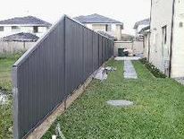 Dark grey Colorbond fence down a narrow side yard