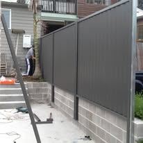 Dark grey Colorbond fence on a rendered plinth