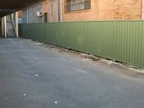 Green Colorbond fence along a driveway