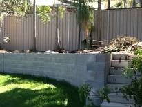 Grey Colorbond fence above a concrete sleeper wall