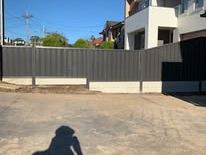 Grey Colorbond fence across a concrete yard