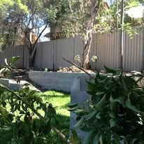 Grey Colorbond fence behind a garden bed