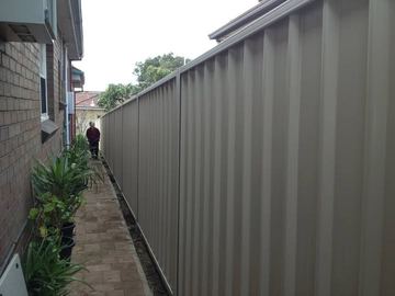 Grey Colorbond fence down a narrow side passage