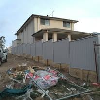 Grey Colorbond fence on a retaining wall during a build