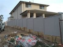 Grey Colorbond fence on a retaining wall during a build