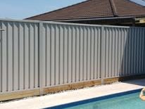 Light grey Colorbond fence beside a swimming pool