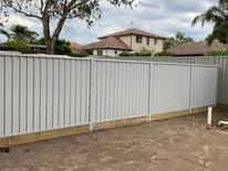 Light grey Colorbond fence on exposed footings